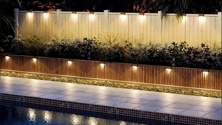 An image of Solpex solar outdoor lights attached to a small fence near a pool