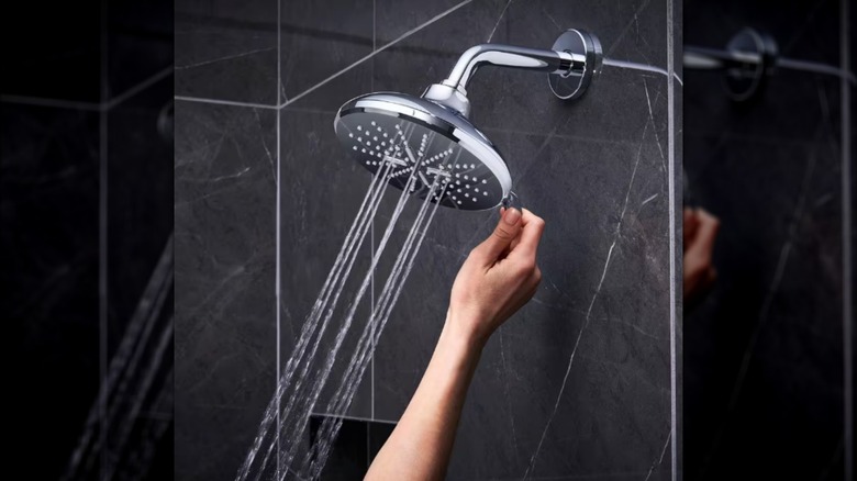 A person adjusting the spray mode on their Grohe Rainshower Smartactive Shower Head