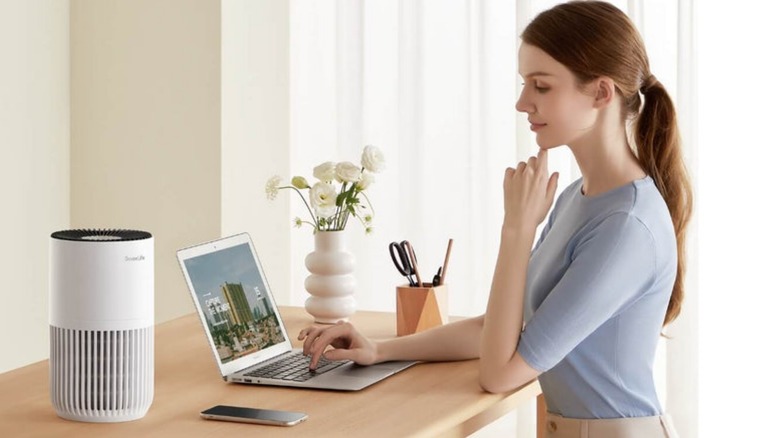 Govee purifier on countertop with person typing on laptop