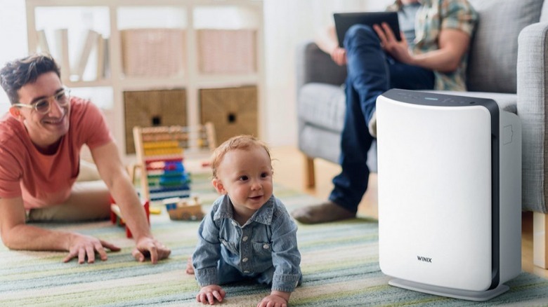 Winix D360 next to baby on floor with parents in background