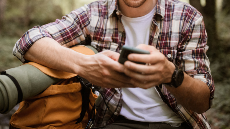 man using a phone in the wild