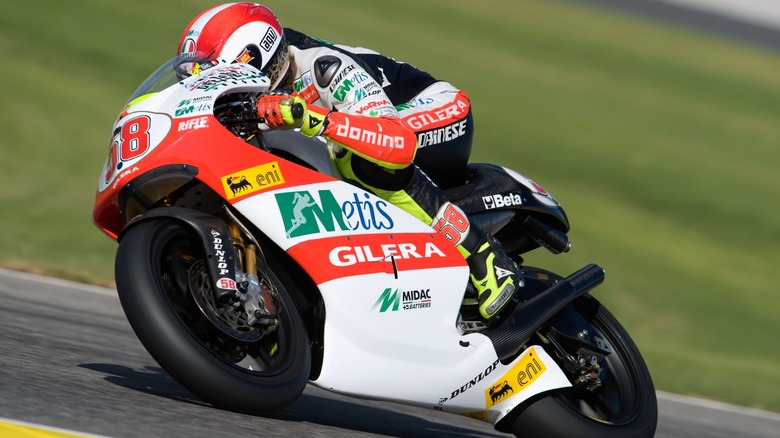 A rider on a Gilera bike rounding the bend at the Valencia circuit