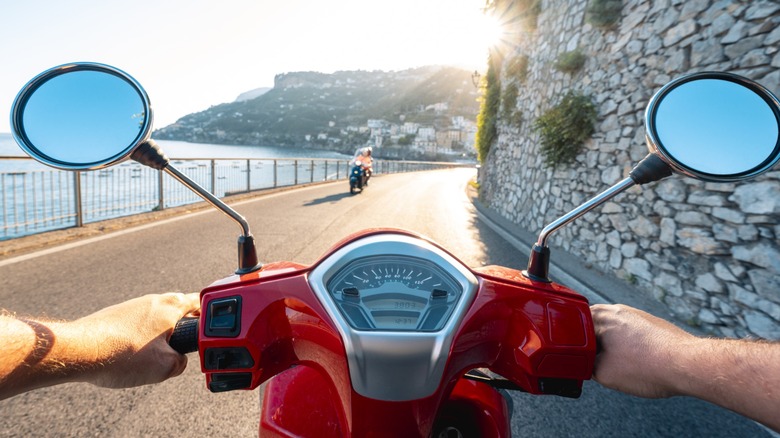 A POV shot of a person riding a red motorcycle