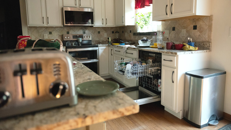 messy suburban kitchen with open dishwasher