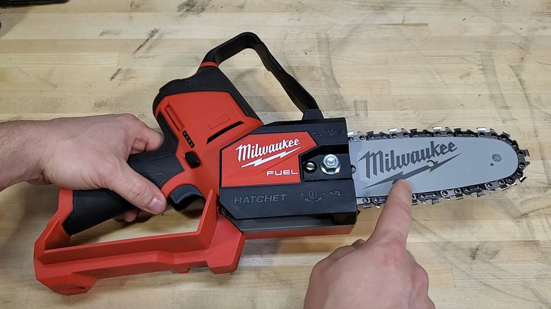 Person holding and pointing at Milwaukee pruning saw