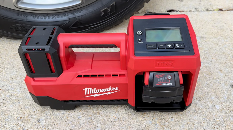 Inflator sitting in pavement next to tire