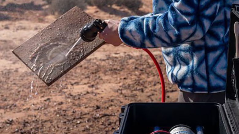 Person cleaning board with water