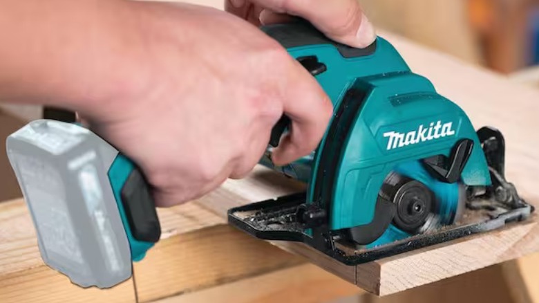 Person using Makita saw on wood