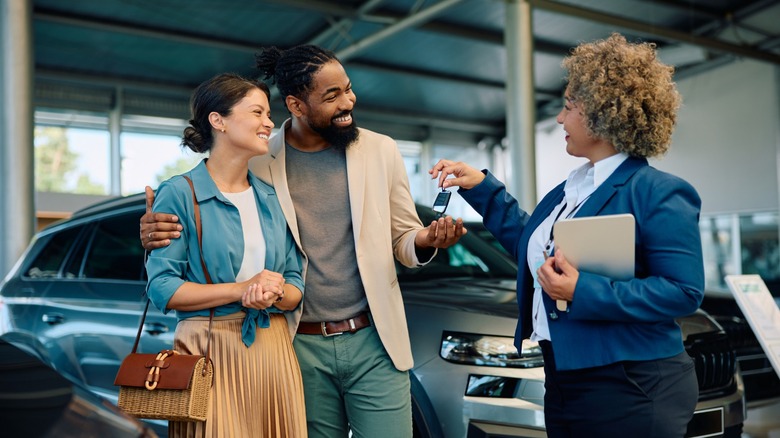 A couple buying a car at a dealership