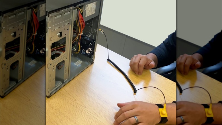 Man uses anti-static wrist strap while repairing a PC