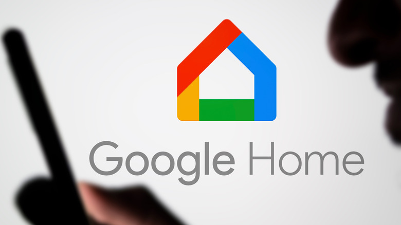 Person holding smartphone in front of Google Home logo