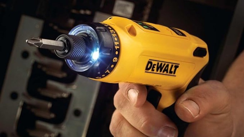 Yellow DeWalt electric screwdriver with light on