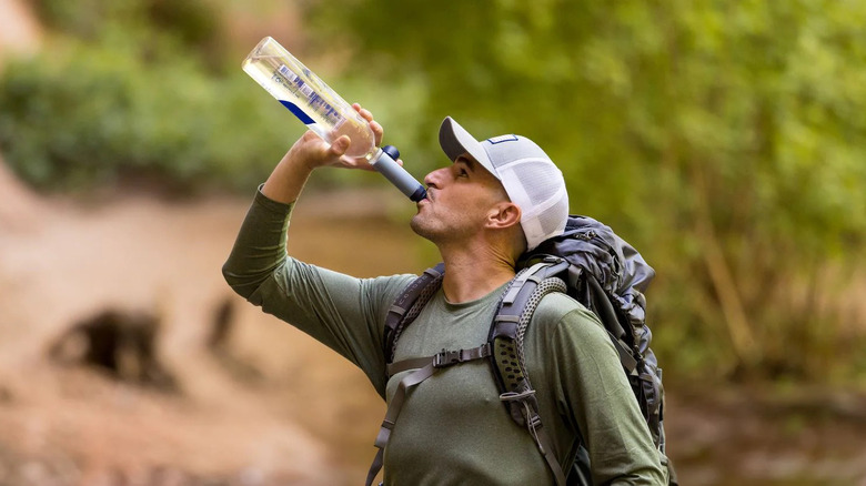 person drinking water through filter