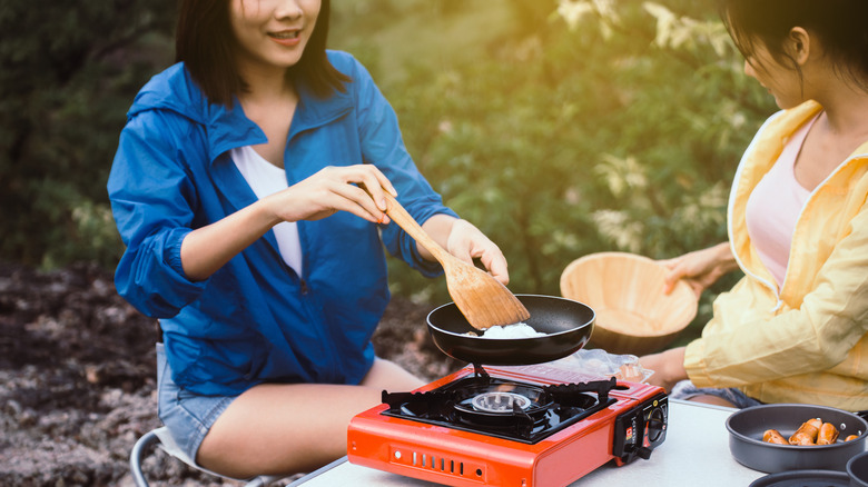 person cooking with portable stove