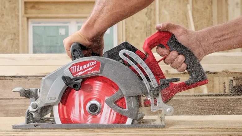 A person cutting wood with an M18 Fuel 7¼-Inch Rear Handle Circular Saw.