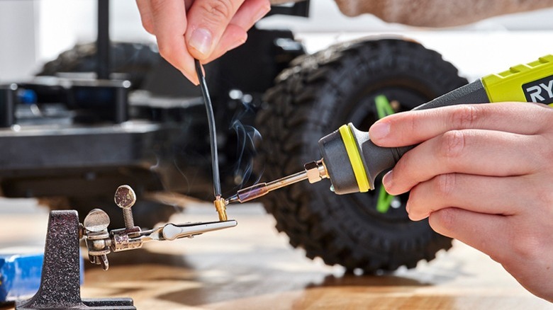 Person using Ryobi soldering iron