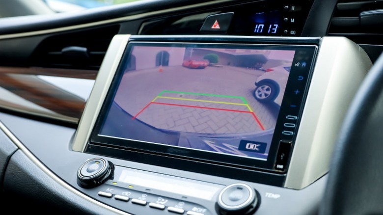 A driver using a car backup camera for parking