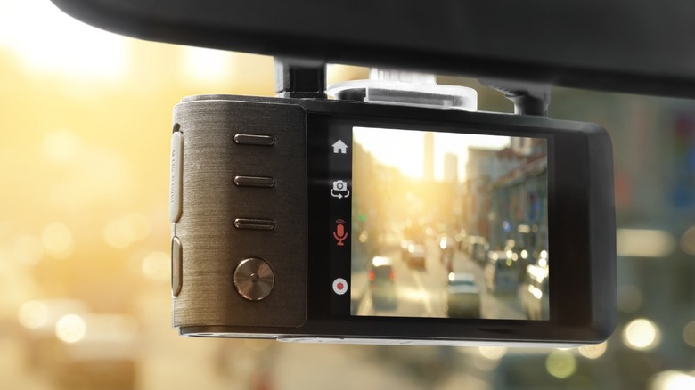 A car dash cam mounted to the rearview mirror