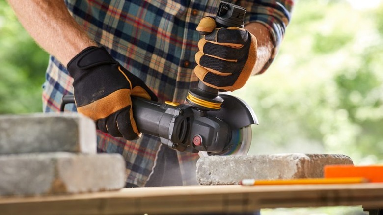 person using Cat 7A 4.5-inch Angle Grinder