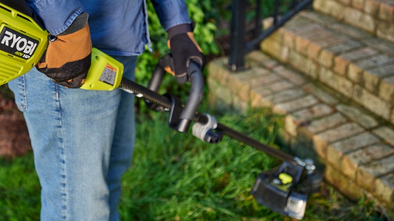 person using Ryobi 40V weed eater