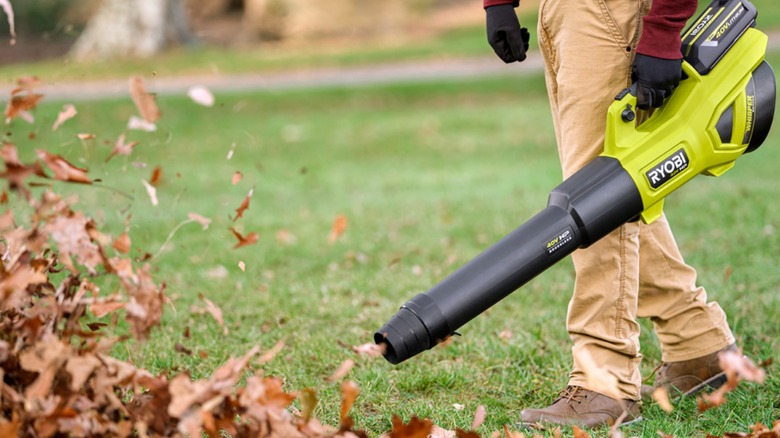 person with Ryobi leaf blower blowing leaves