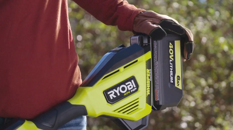 person holding ryobi 40v battery and tool