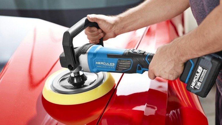 A person using a Hercules power sander to buff their car