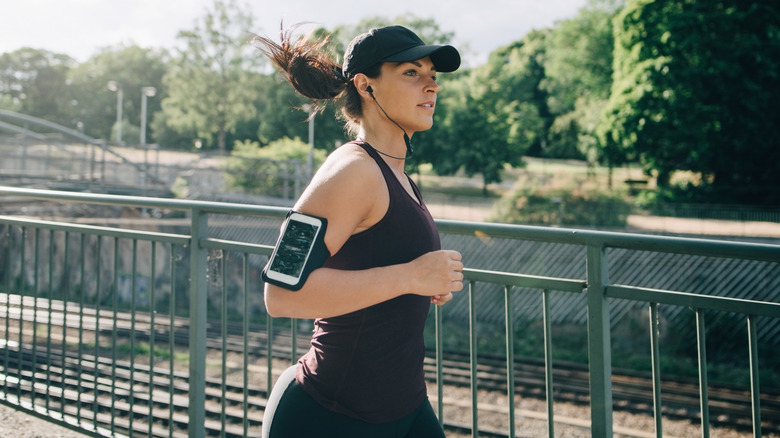 person running with smartphone and headphones