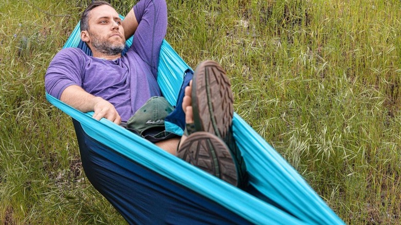 Man relaxing in a Parachute hammock