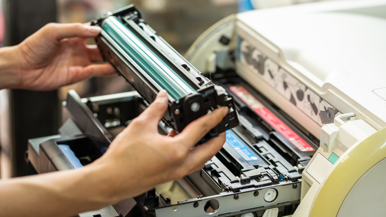 person changing printer toner