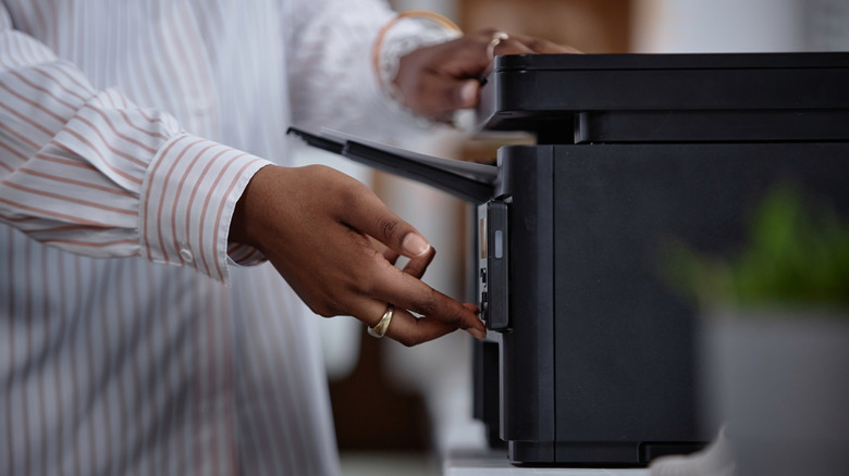 side view person using laser printer