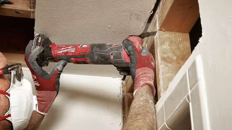 Person using an oscillating tool on a wall