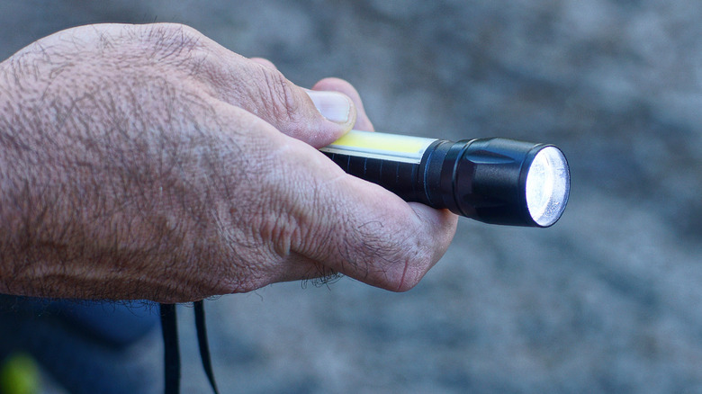 Hand holding pocket flashlight