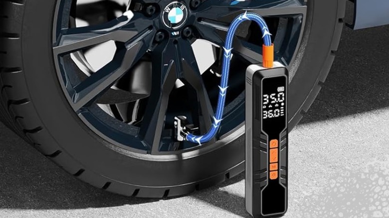 A close-up of a Hajomel portable tire inflator being used to fill a car tire