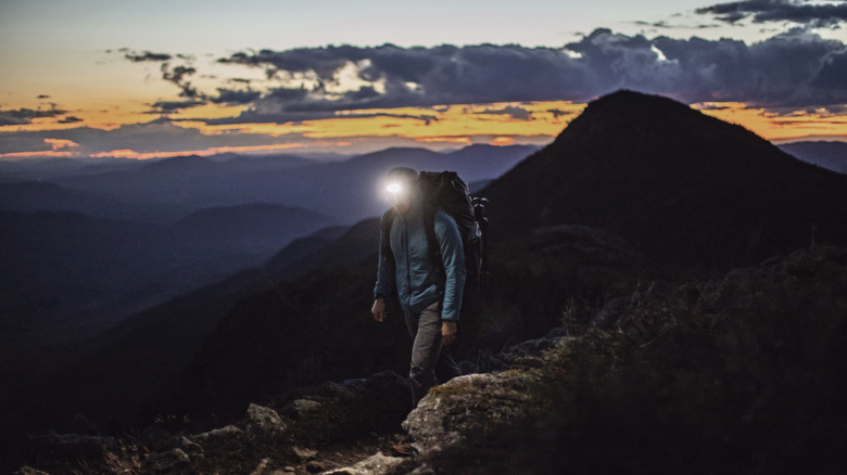 Hiker at dusk wearing headlamp