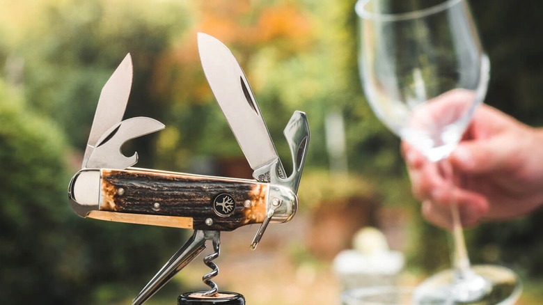 Böker Camp Knife Stag with tools open and corkscrew being used to open wine bottle