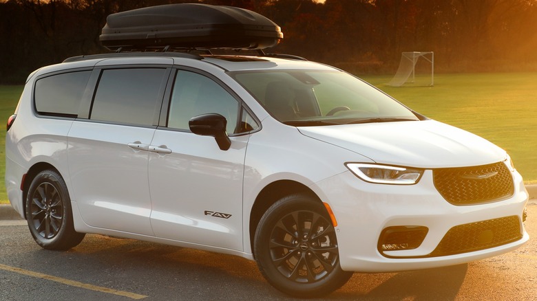 A white 2025 Chrysler Pacifica Family Adventure Vehicle Edition parked near a soccer field.