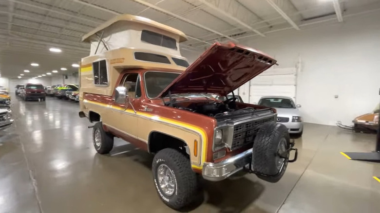 Burnt orange 1977 Chevy Blazer Chalet with camper shell parked in showroom