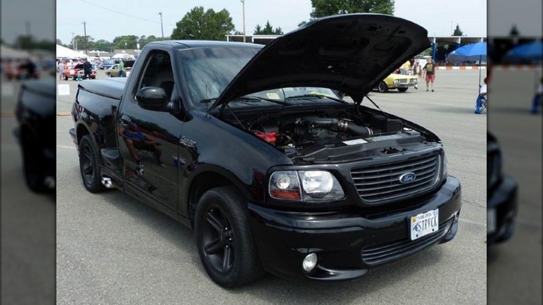 A black Ford SVT F-150 Lightning on display at a car show.