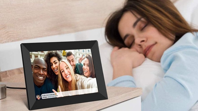 woman sleeping next to digital frame