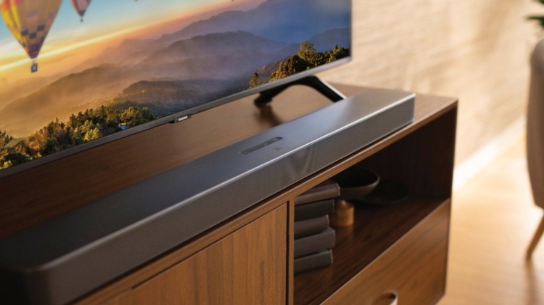 An image of a jbl 5.1 channel soundbar beneath a tv on a piece of furniture