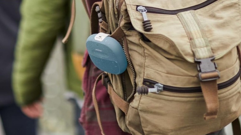 Bose SoundLink Micro Bluetooth speaker clipped on a hiker's backpack