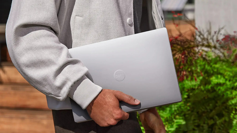 man holding Dell XPS 14 9440