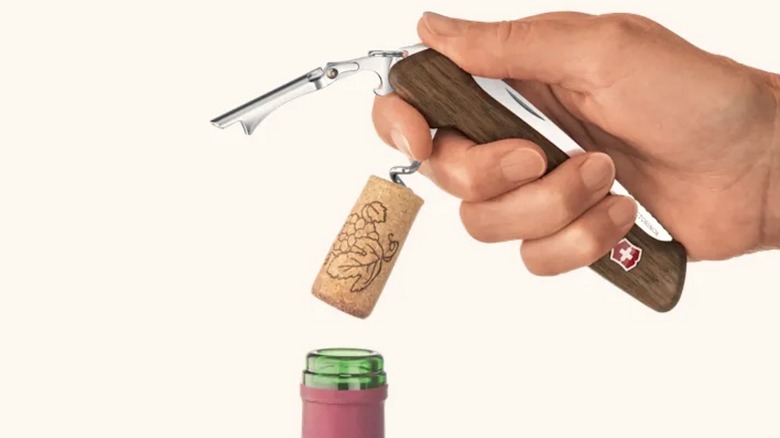 Person pulling cork with Swiss Army Wine Master Wood Knife