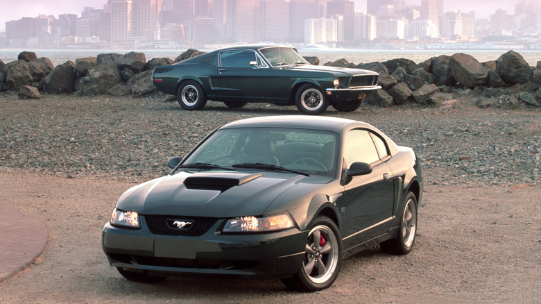 1960s and 2001 Ford Mustang Bullitt cars parked near shore