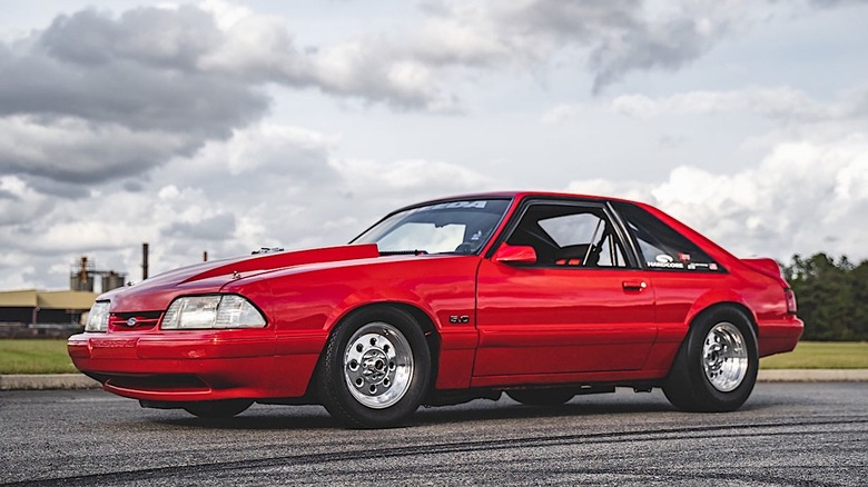 Red Ford Mustang Foxbody parked on track