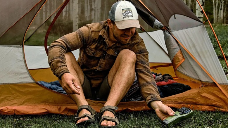 Camper using Thermacell MR300 Portable Mosquito Repeller in front of tent