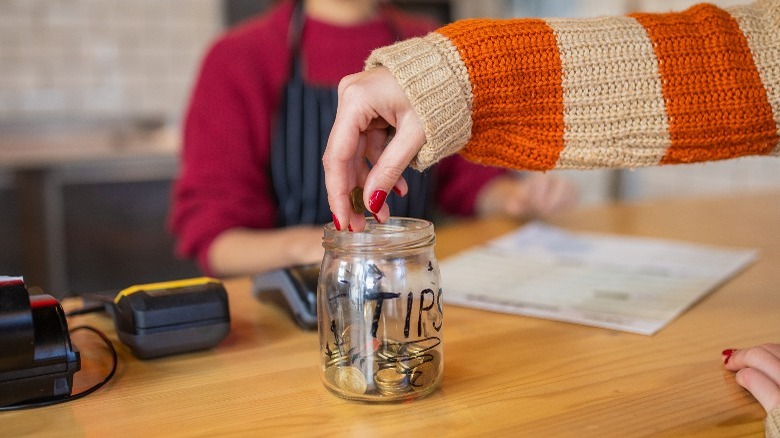  female customer leaving tips at the tip jar