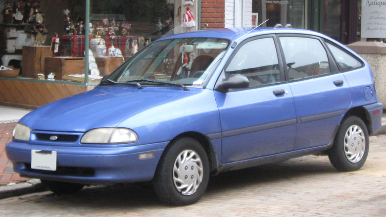 Blue Ford Aspire four door hatchback parked on street