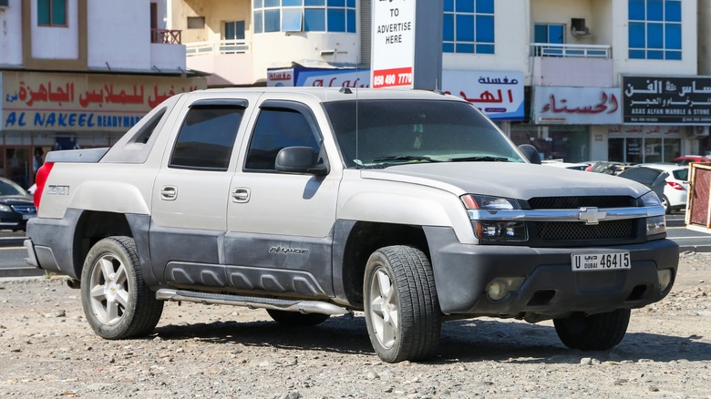 A Chevy Avalanche parked on a gravel street